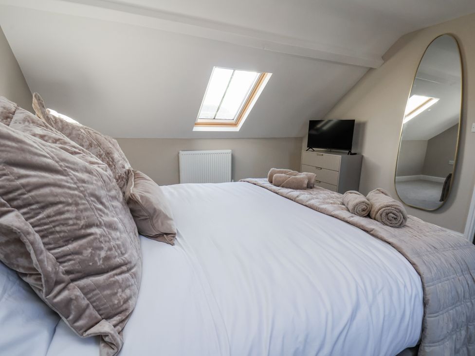 A bedroom with a bed, television, and dresser at 2 bed in Scarborough