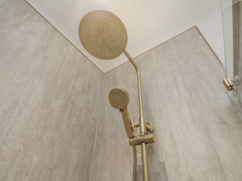 A shower with a large shower head and handheld shower at 2 bed in Scarborough