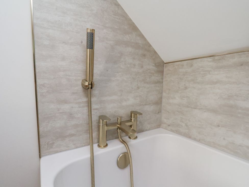 A bathtub with a faucet and showerhead at 2 bed in Scarborough