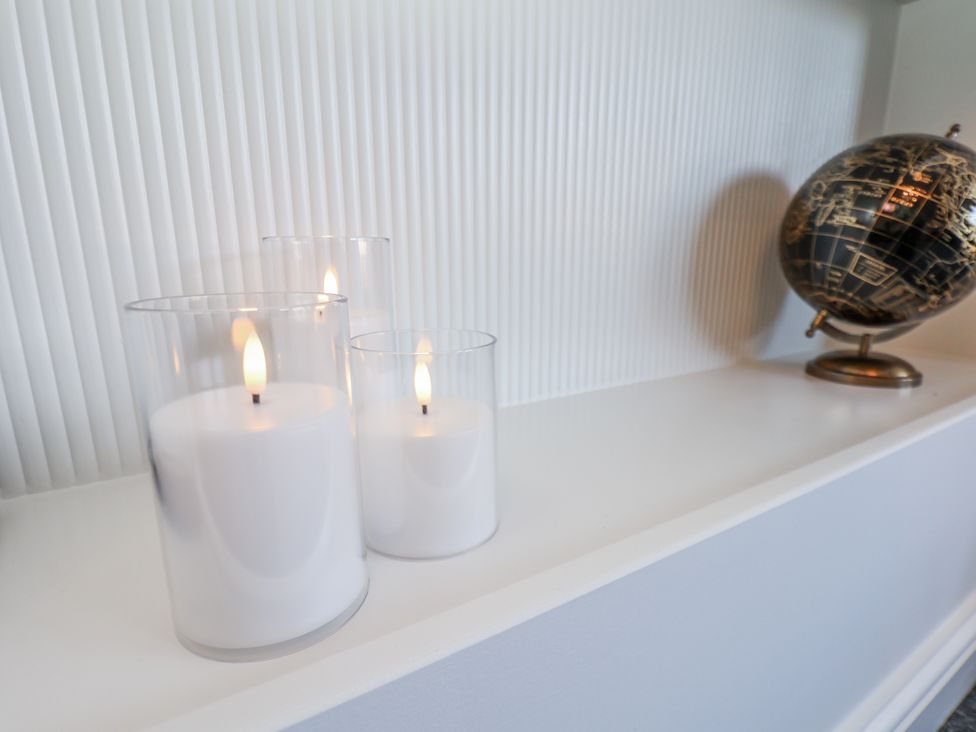 Candles and a globe on a shelf in a living room at 2 bed Scarborough