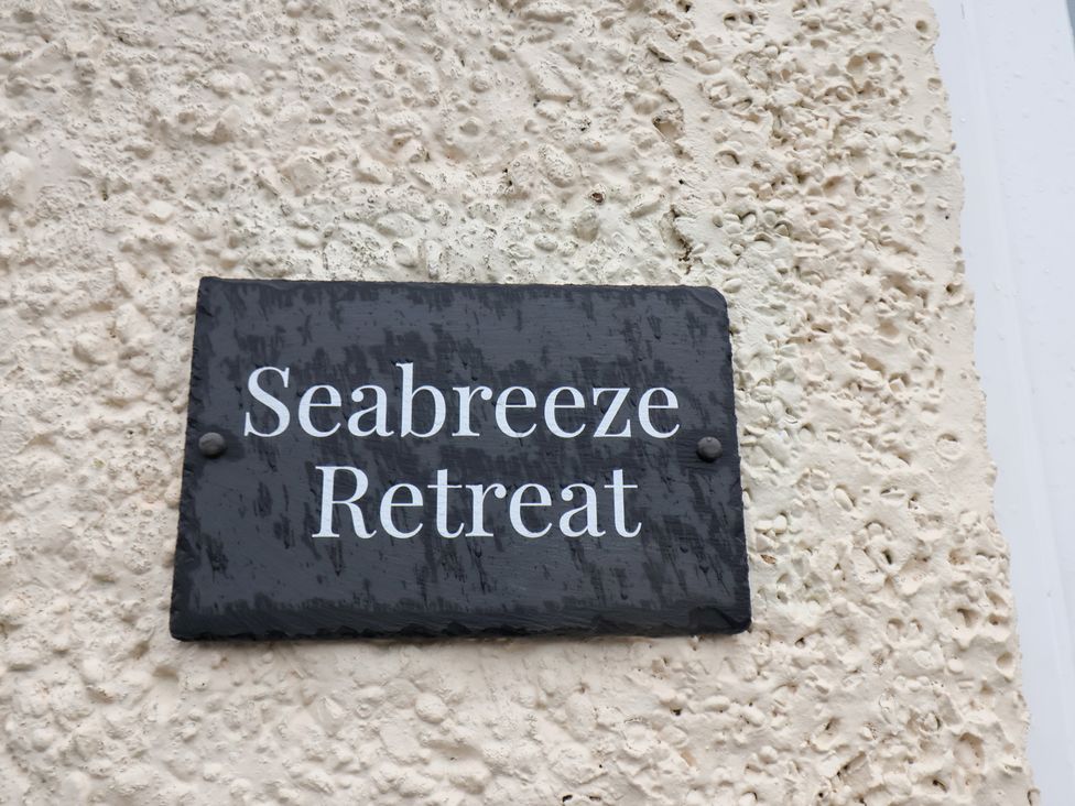 A sign displaying Seabreeze Retreat on a wall