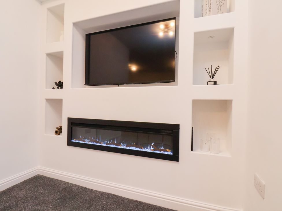 A living room with a television and electric fireplace at Maxwell View in Scarborough
