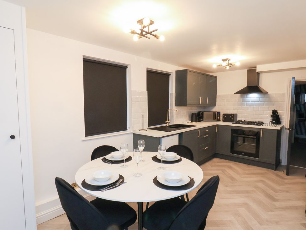 A kitchen with a dining table and kitchen appliances at Maxwell View in Scarborough