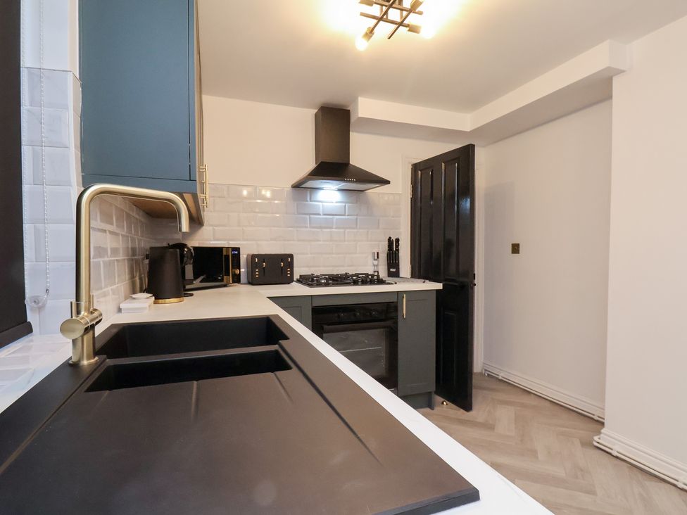 A kitchen with a sink, cooker, and microwave at Maxwell View in Scarborough
