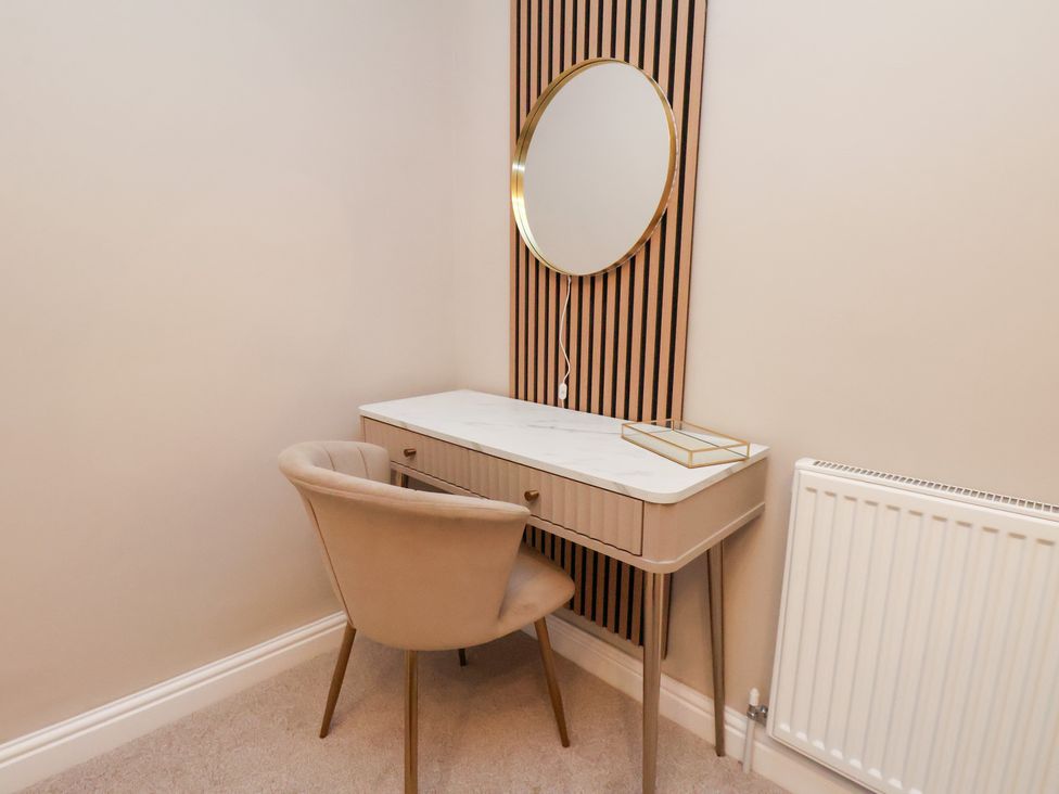 A dressing room with a vanity table and a mirror at Maxwell View in Scarborough