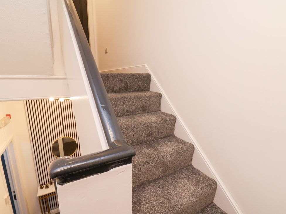 A staircase leading up with handrail and wall at Maxwell View in Scarborough