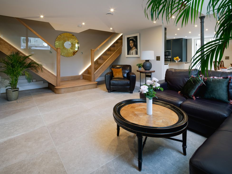 A living room with a staircase and furniture at The School House in Newton Abbot