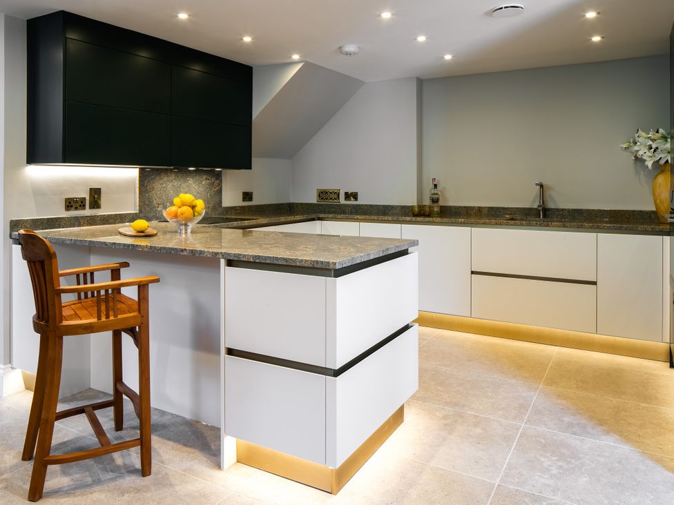 A kitchen with a countertop and bar stool at The School House in Newton Abbot