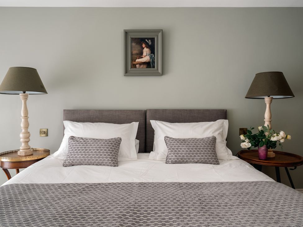 A bedroom with a bed and lamps at The School House in Newton Abbot