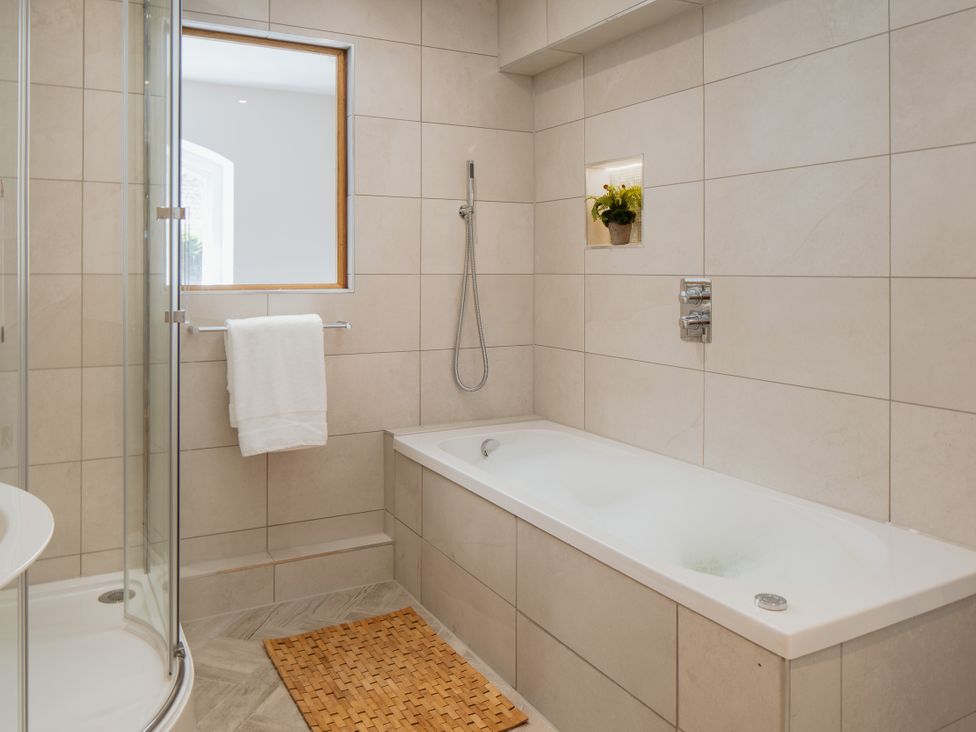 A bathroom with a bathtub and shower at The School House in Newton Abbot