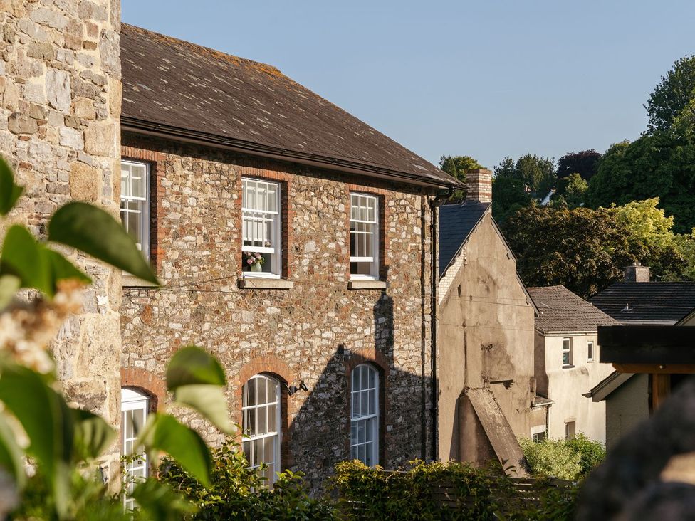 An outdoor view of buildings and greenery at The School House in Ashburton