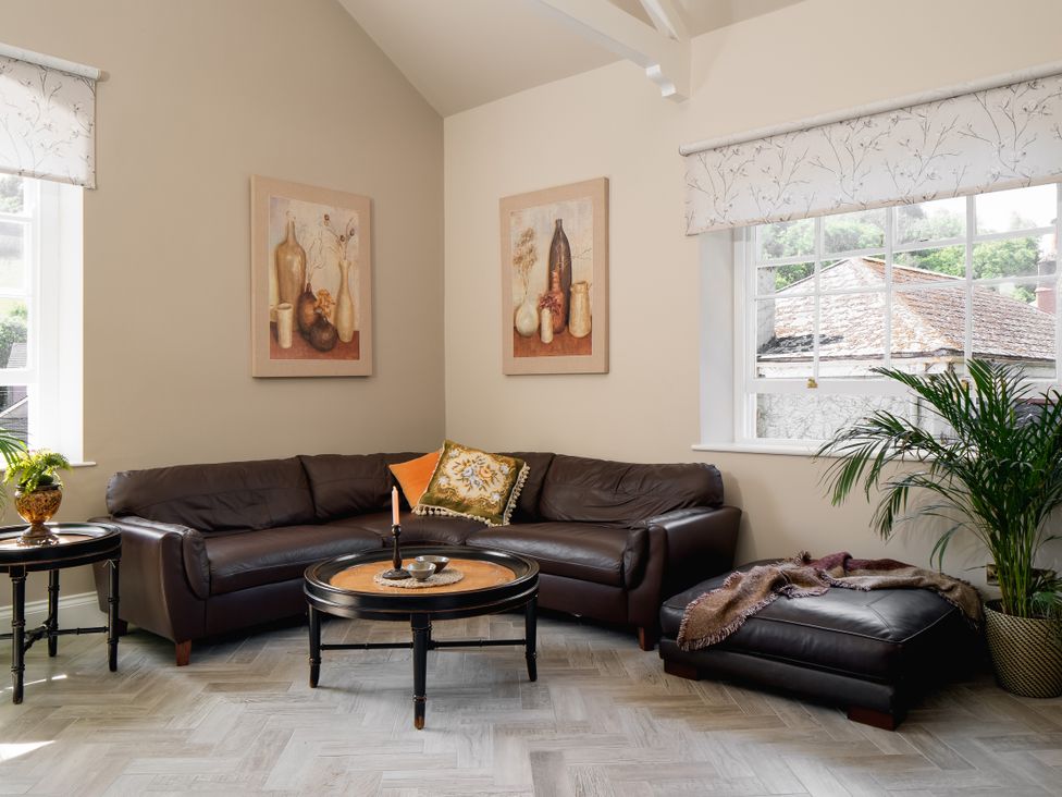 A living room with a leather sofa and coffee table at Upper School House in Newton Abbot