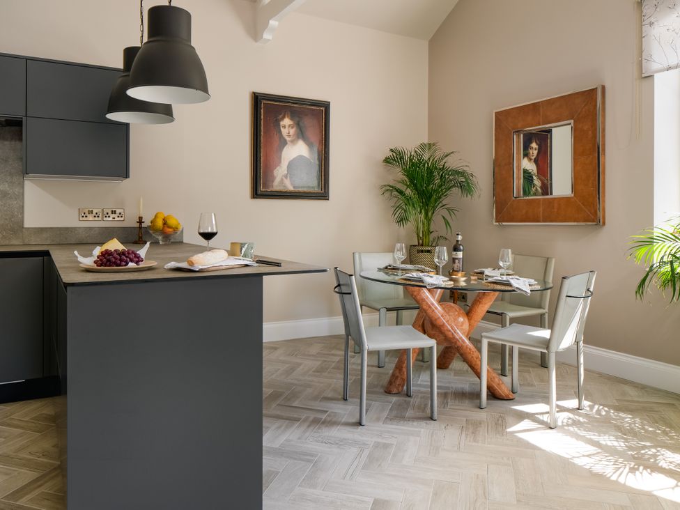 A dining room with a glass table and chairs at Upper School House in Newton Abbot