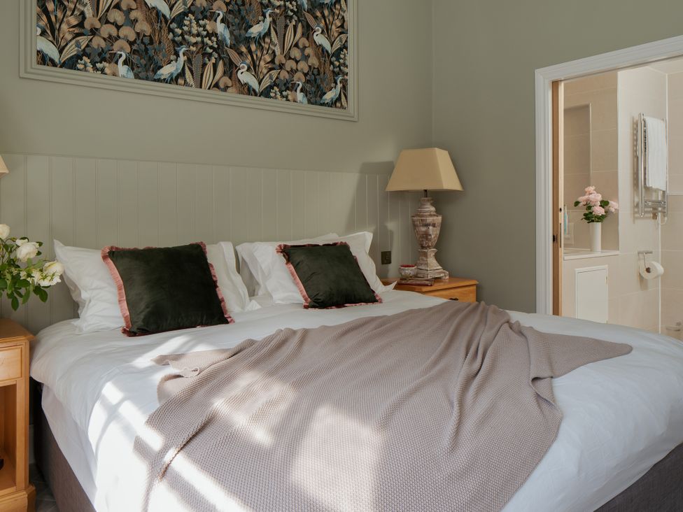 A bedroom with a bed and flowers on a bedside table at Upper School House in Newton Abbot