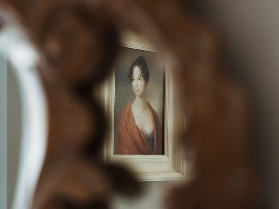 A painting of a woman reflected in a decorative mirror at Upper School House in Newton Abbot