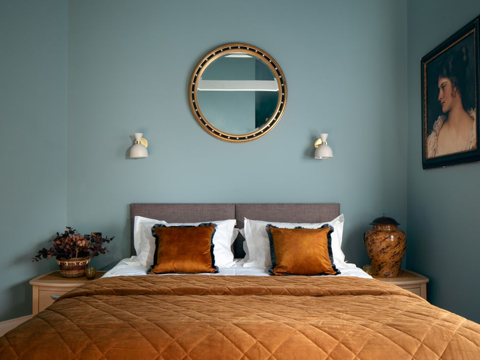 A bedroom with a bed and decorative items at Upper School House in Newton Abbot
