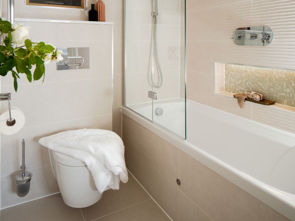 A bathroom with a bathtub, toilet, and towel at Upper School House in Newton Abbot