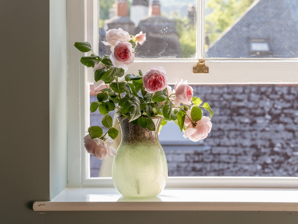 A vase with roses on a windowsill at Upper School House in Newton Abbot