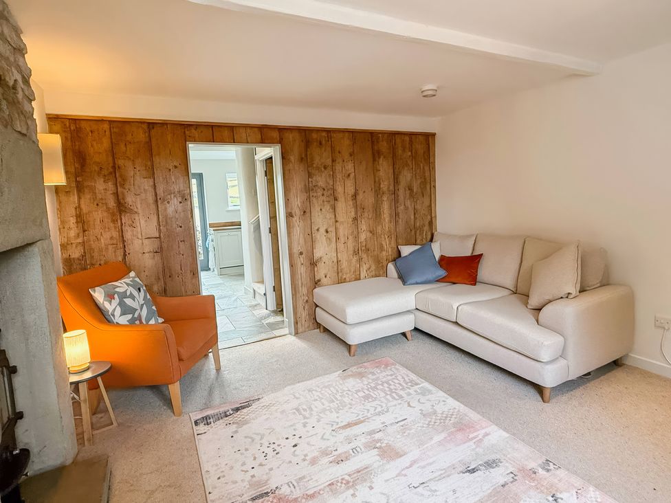 A living room with a sofa and armchair at 7 Litton Slack in Tideswell