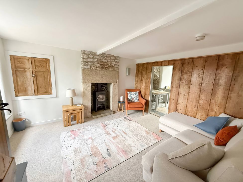 A living room with a fireplace and sofa at 7 Litton Slack in Tideswell