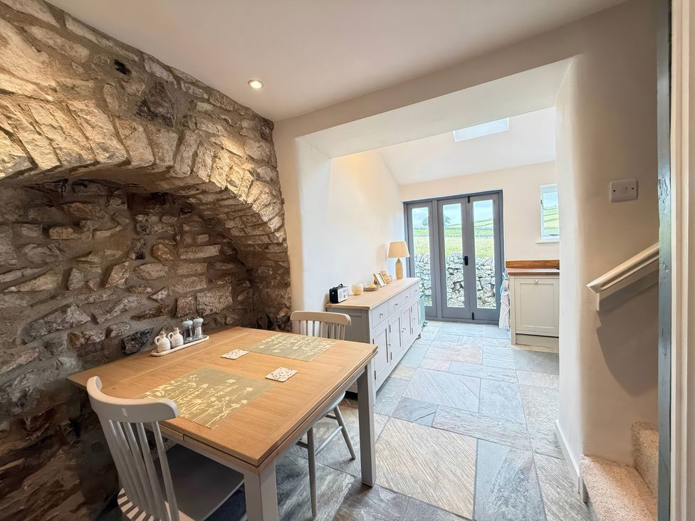 A dining room with a table and chairs at 7 Litton Slack in Tideswell