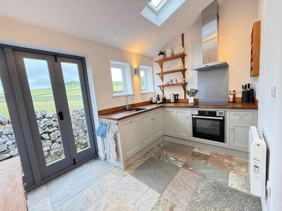 A kitchen with various appliances and windows at 7 Litton Slack in Tideswell