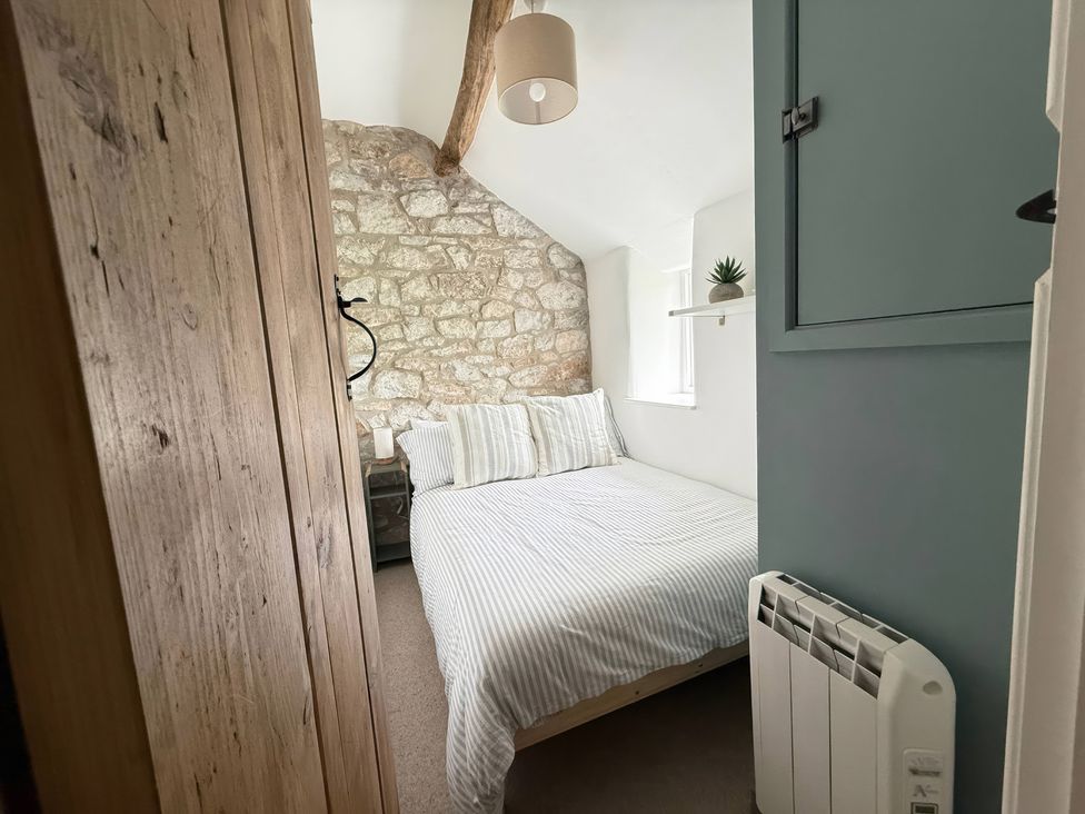 A bedroom with a bed and windows at 7 Litton Slack in Tideswell