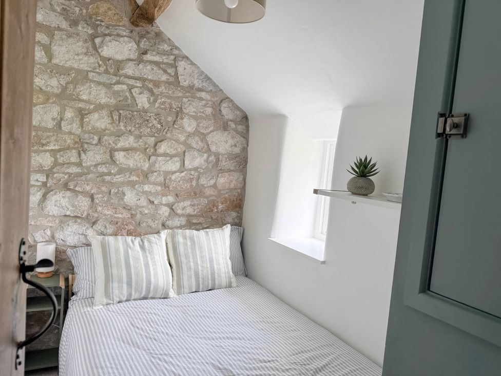 A bedroom with a bed and a plant on a shelf at 7 Litton Slack Tideswell