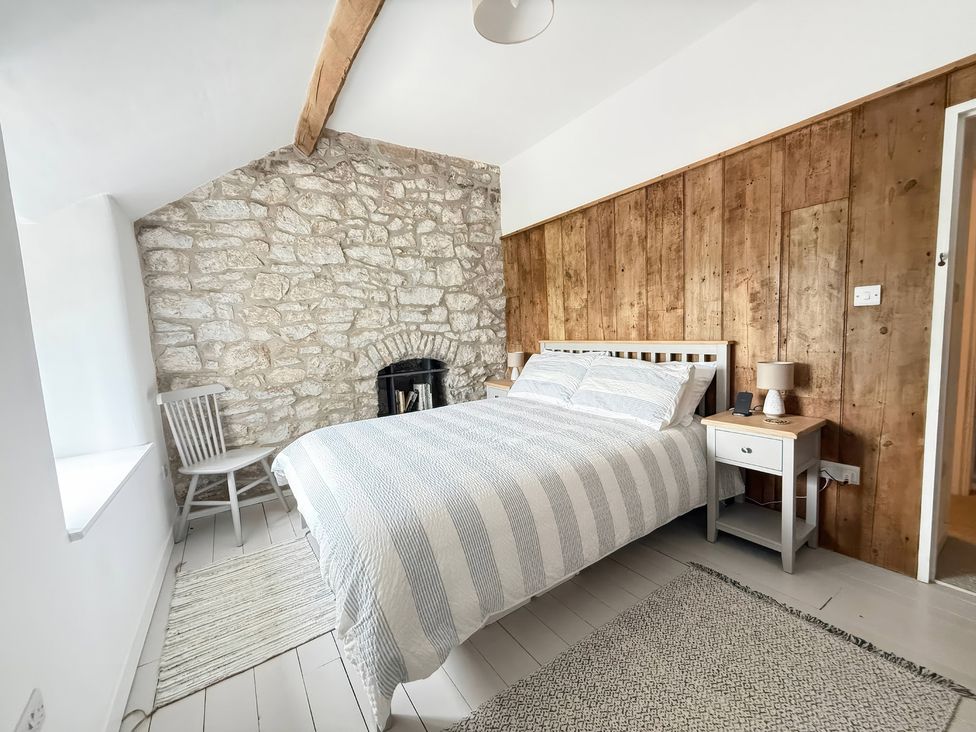 A bedroom with a bed and a chair at 7 Litton Slack in Tideswell