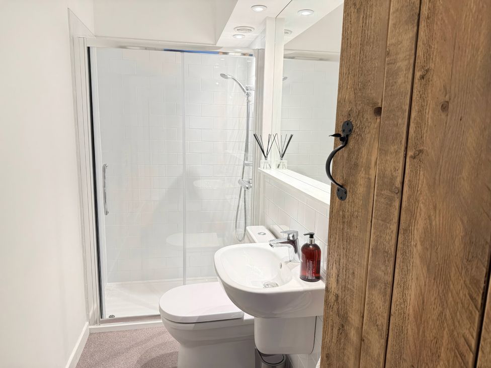 A bathroom with a shower, toilet, and sink at 7 Litton Slack in Tideswell