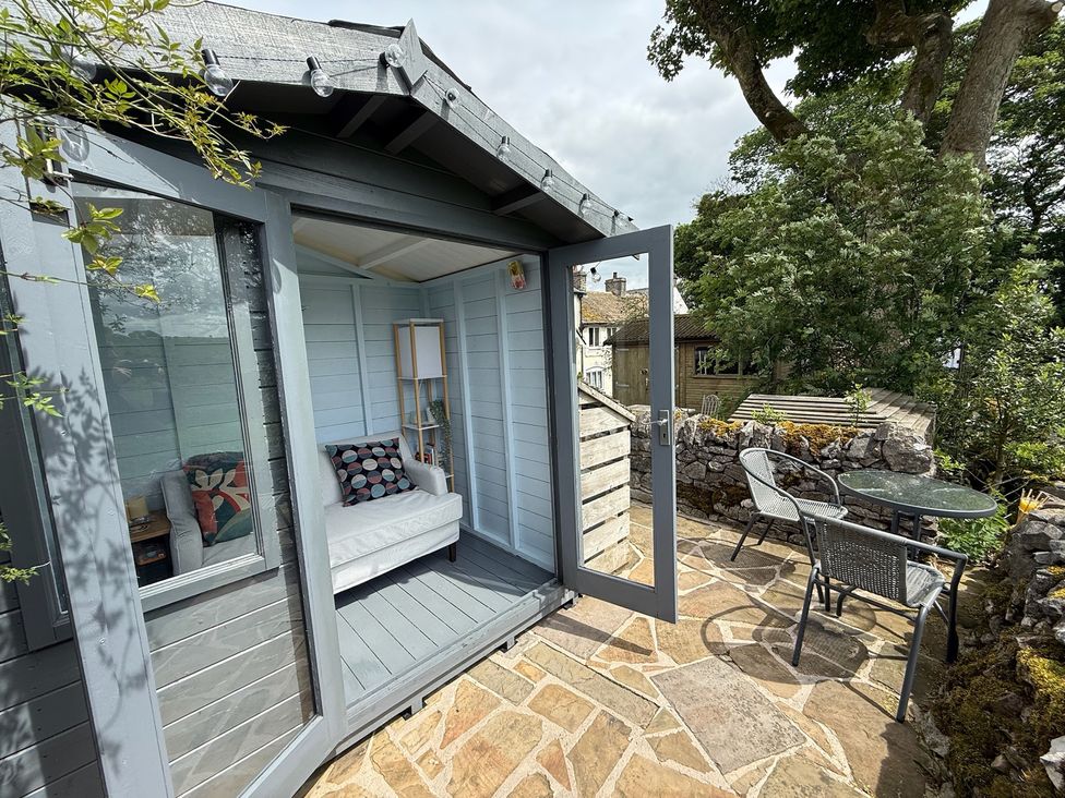 A garden shed with a sofa and lamp at 7 Litton Slack in Tideswell