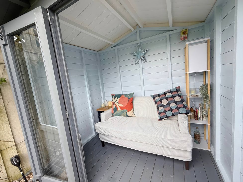 A garden room with a sofa and shelves at 7 Litton Slack Tideswell
