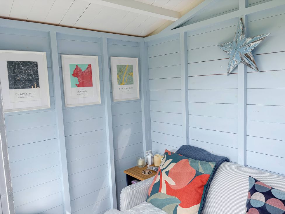 A snug with a sofa, table and framed artworks at 7 Litton Slack in Tideswell