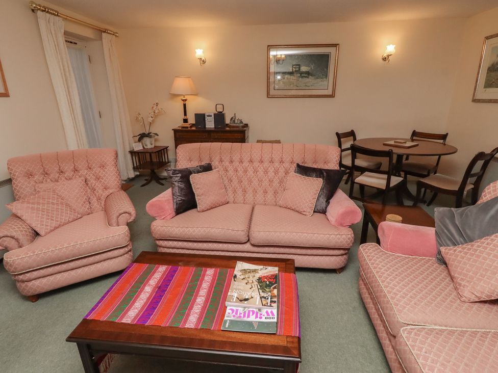 A living room with sofas and a dining table at Grange Cottage in Belford