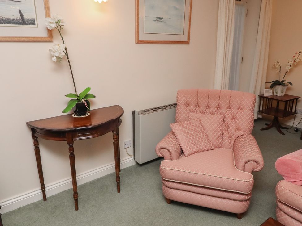 A living room with an armchair and side table at Grange Cottage in Belford