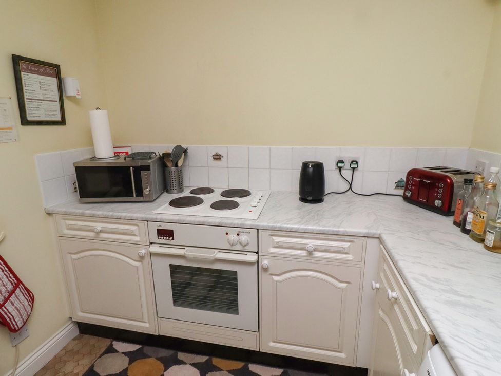A kitchen with appliances including a microwave, kettle, and toaster at Grange Cottage in Belford
