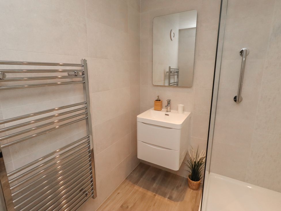 A bathroom with a towel rail and sink at Grange Cottage in Belford