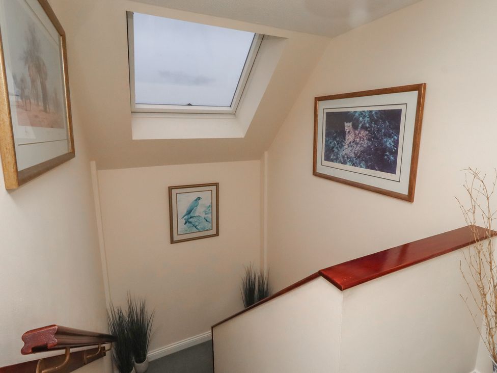 A staircase with wall art and a skylight at Grange Cottage in Belford