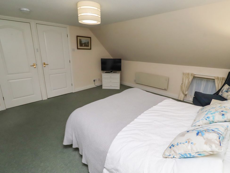 A bedroom with a bed and television at Grange Cottage in Belford