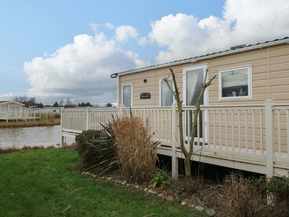 An outdoor area with a mobile home and deck at 62 Guddlebeck in Flookburgh