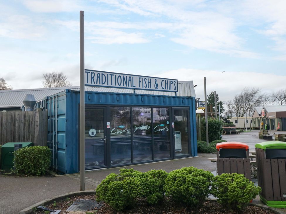 A fish and chips shop with a sign at Cook's in Flookburgh