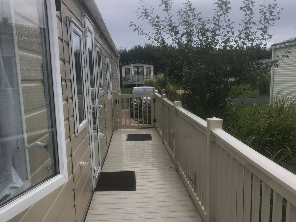 A pathway with a car and surrounding greenery at 62 Guddlebeck in Lakeland Leisure Park, Flookburgh