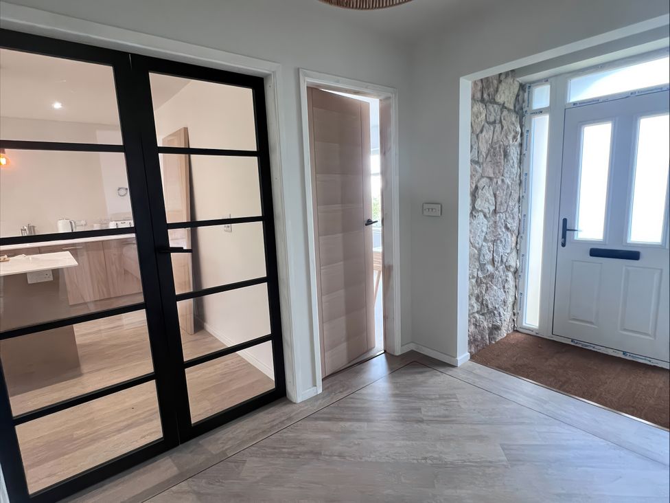 An entrance hall with glass doors and a front door at 81 Lon Gogarth Benllech