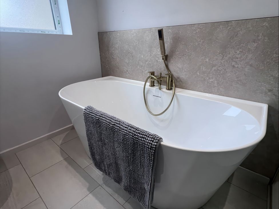 A bathroom featuring a bathtub and a window at 81 Lon Gogarth in Benllech
