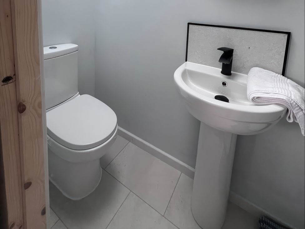 A bathroom with a toilet and sink at 81 Lon Gogarth in Benllech