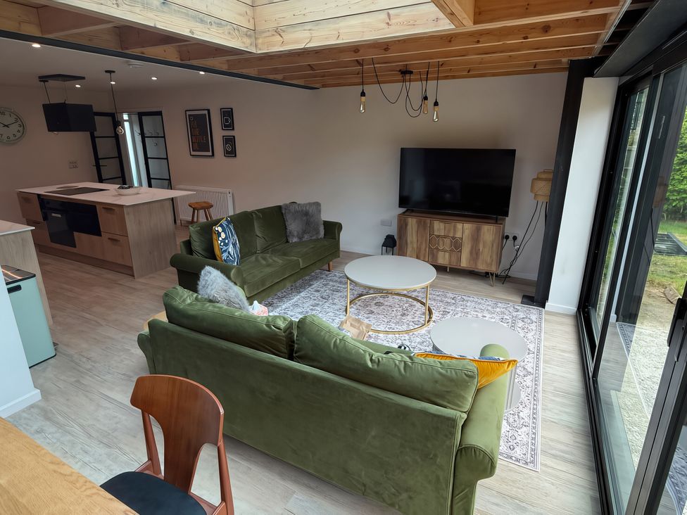 A living room with a sofa and television at 81 Lon Gogarth Benllech