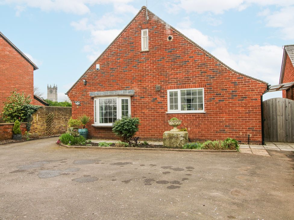 An outdoor view of a brick house with garden and path at The Rumbles