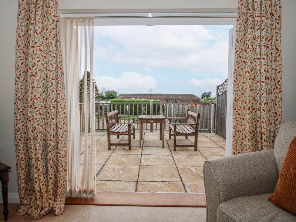 An indoor photo showing a patio area with a table and chairs at The Rumbles in 