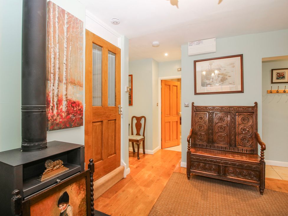 A hallway with a wooden door and a bench at The Rumbles in 