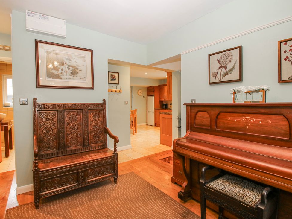 A living room with a bench and piano at The Rumbles in 